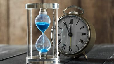 time is passing blue hourglass close up العلاقة بين معنى الزمان والسببية